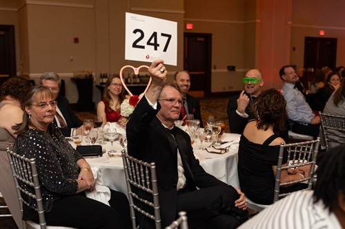 Photo of a man holding up paddle number 247